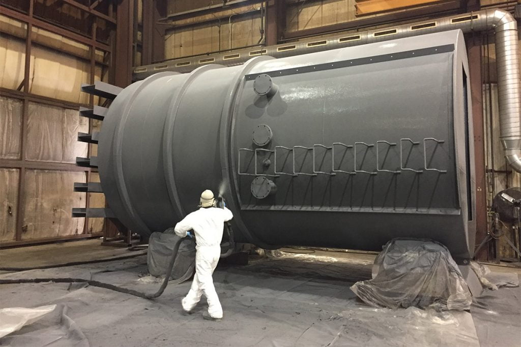 Man spraying Fabick coating on containment tank